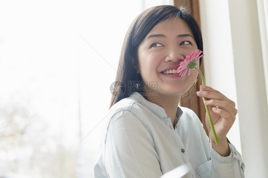 女人闻花朵图片