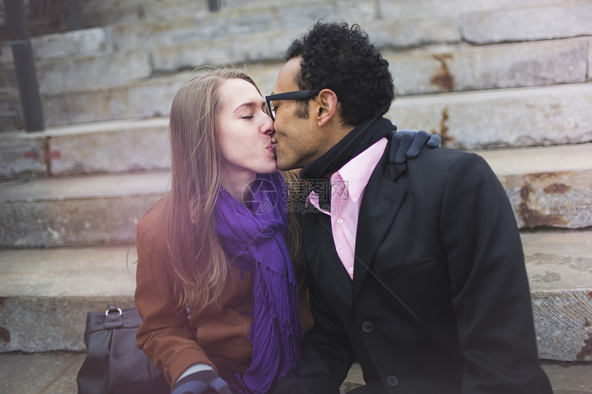 年轻夫妇在城市台阶上接吻图片