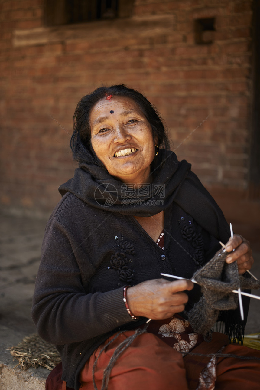 尼泊尔加德满都Thammel街上女商贩在编织图片