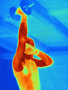 年轻男运动员用哑铃训练时的热图像显示了肌肉产生的热量图片