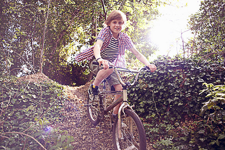 森林骑自行车的男孩图片
