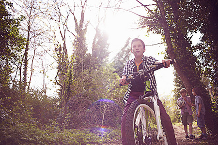 在森林里骑自行车的男孩图片