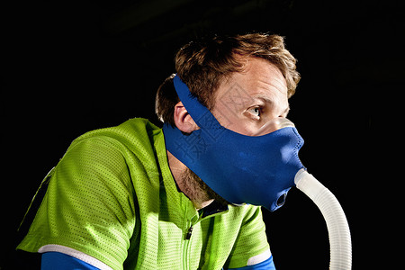 在高原训练健身操场进行低氧训练时戴面罩的青年男子图片