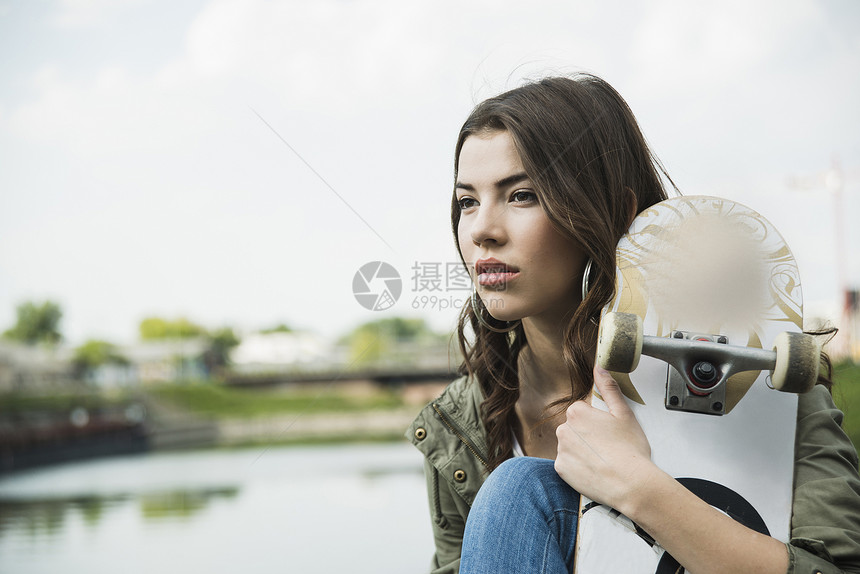 身带滑板的年轻妇女图片