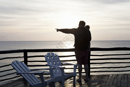 父亲抱着女儿看海上日出图片
