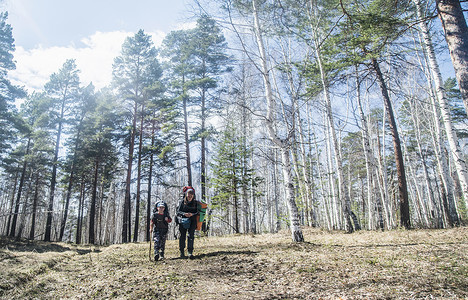 青年男子和儿童在森林中徒步图片