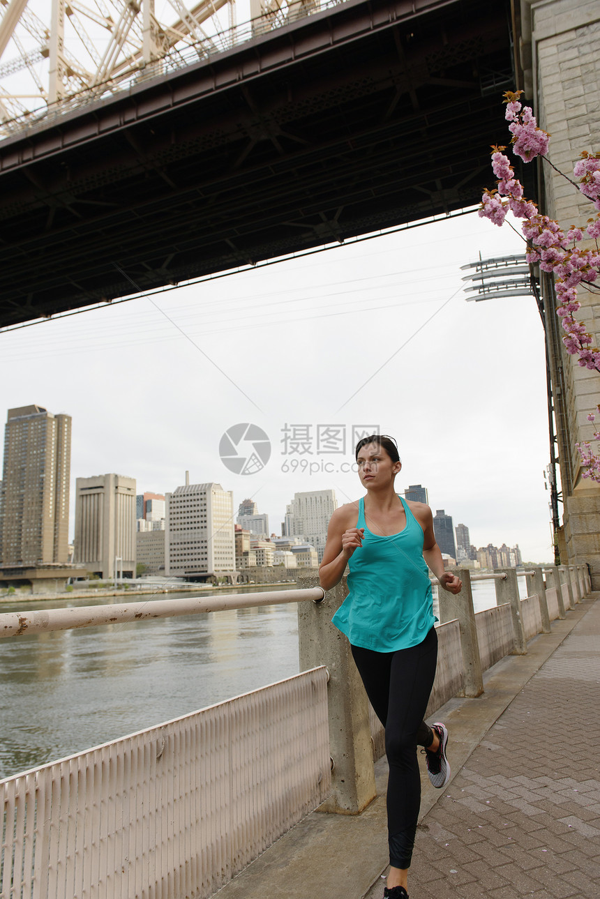 美国纽约市罗斯福岛水边跑步的年轻妇女图片