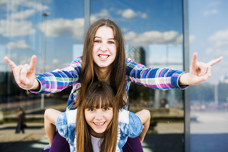 在办公楼外墙玻璃前两名年轻妇女摆姿势图片