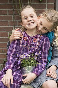 两个姐妹坐在花园里抱着花盆的肖像图片