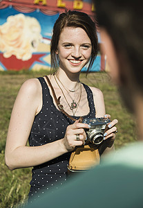 年轻夫妇游乐园用摄影机拍照图片