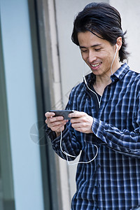 男子走在城市街道上用手机听音乐图片