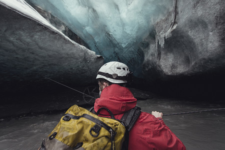 冰岛瓦特那约库尔公园冰川冰洞里的人拽着绳子过河图片