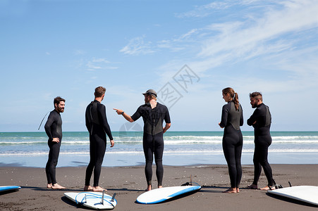 一群男女冲浪者在海滩聊天图片