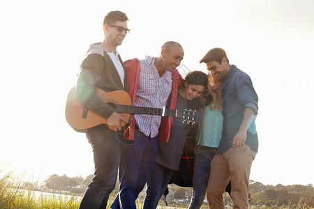 在伯恩茅斯海滩上五个朋友带着音响吉他狂欢图片