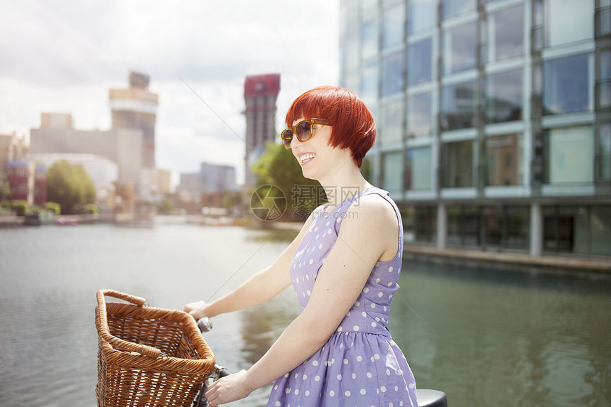 沿运河骑自行车的年轻女性图片
