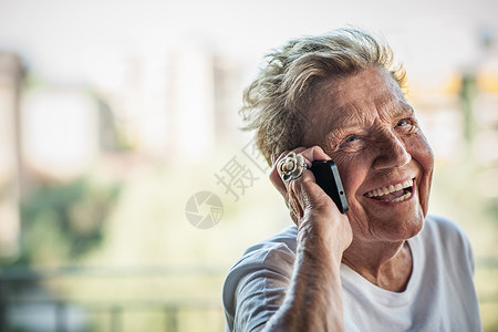 年长的女性在阳台上使用智能手机聊天图片
