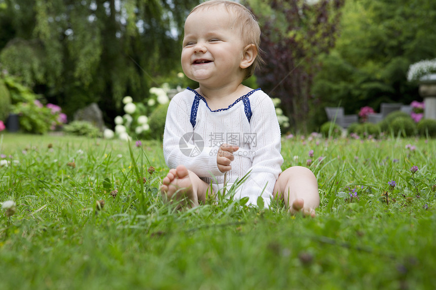 坐在草坪上微笑的女婴肖像图片