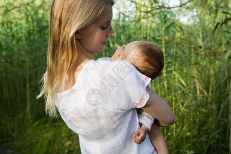 母亲怀里抱着睡觉的女婴图片