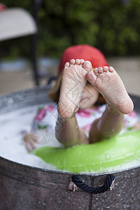 女孩坐在花园的浴盆里露出脚图片