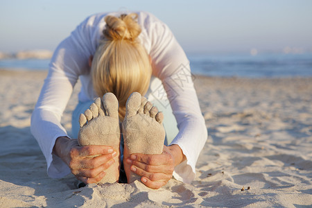 在海滩上做瑜伽的女人背景图片