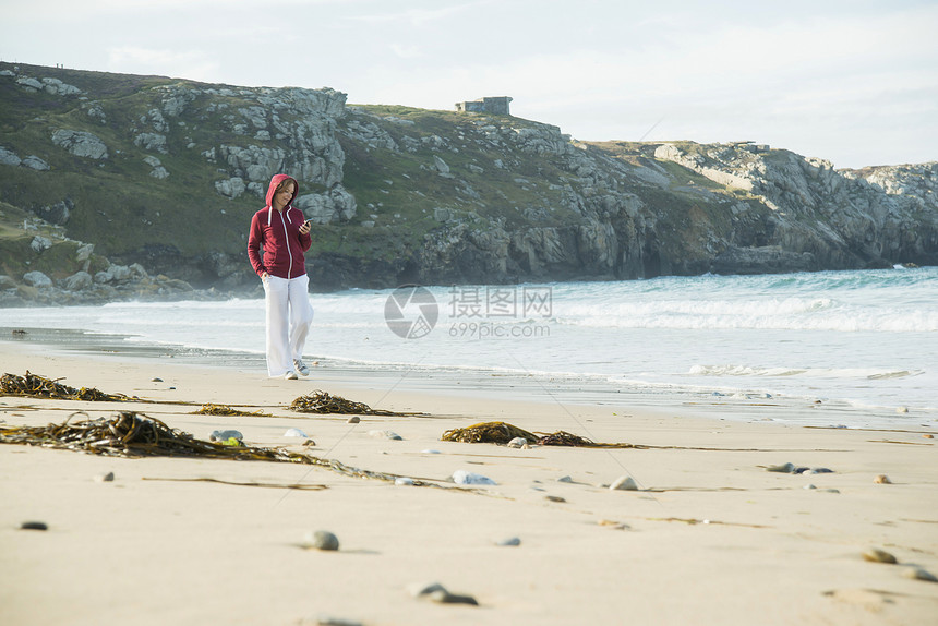 在海滩漫步的年轻女性图片