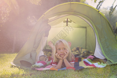 趴在户外帐篷里玩耍的小女孩图片