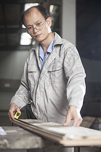 在江苏工厂测量木板的木匠图片