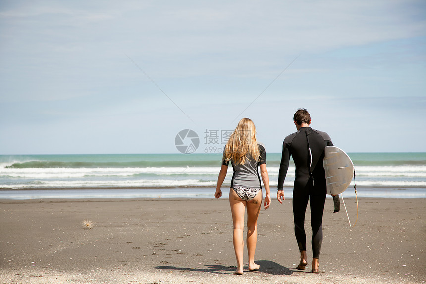 年轻夫妇出海年轻男子携带冲浪板图片