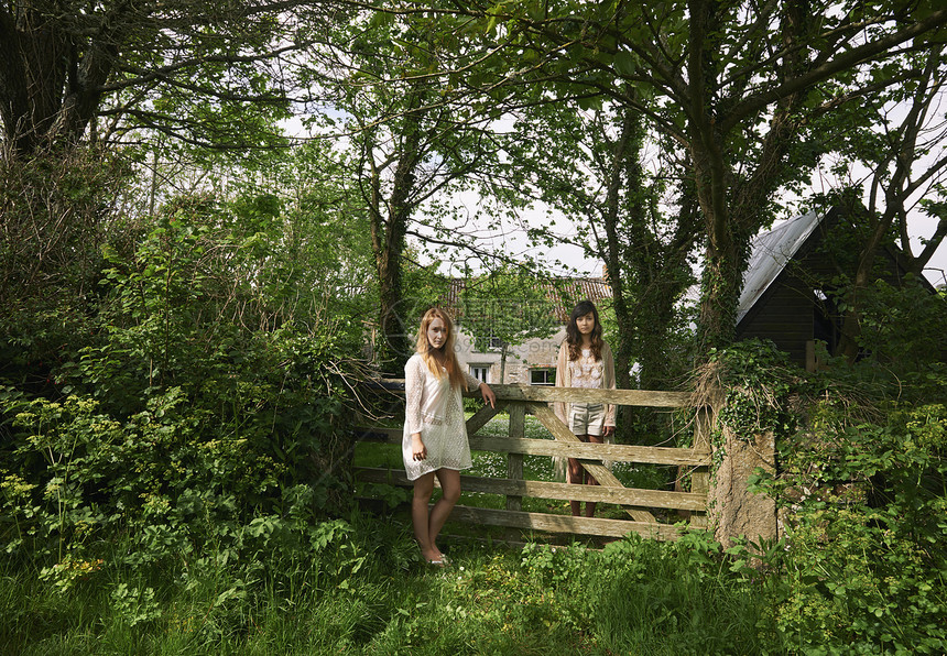 两名年轻妇女站在野外门观视的肖像图片