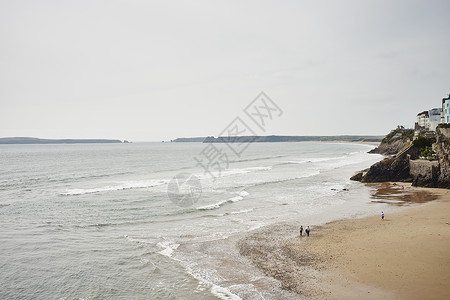 人们在威尔士丹比南海滩上漫步的远视景象图片