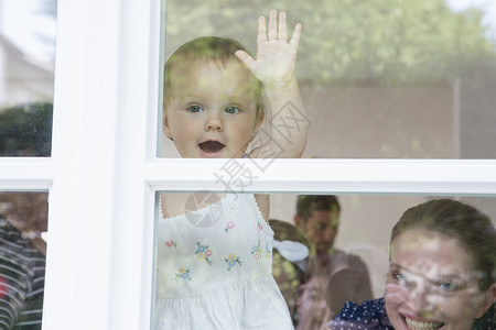 婴儿女孩和母亲向窗外看图片