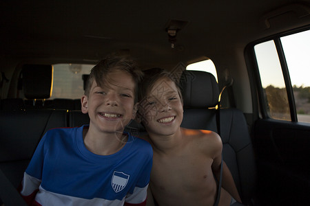 兄弟们的肖像在汽车后座上微笑图片