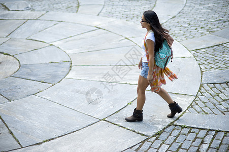 年轻女子走在铺路板上图片