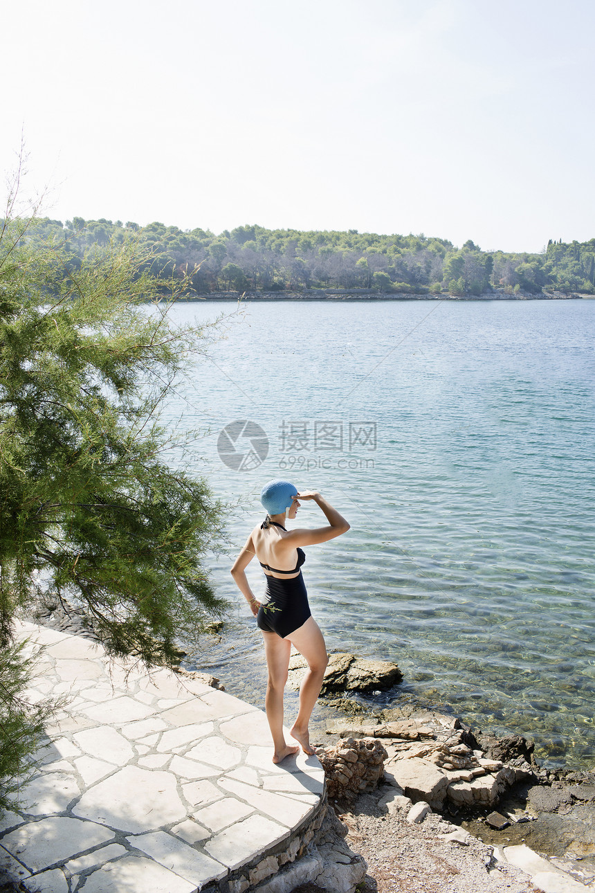 穿游泳服的年轻女子眺望大海图片