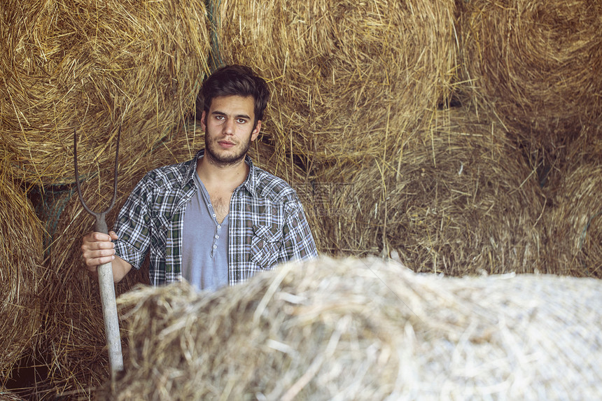 草棚里年轻男农民图片