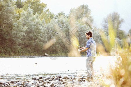 在意大利皮埃蒙特韦尔巴尼亚河捕鱼的年轻人图片
