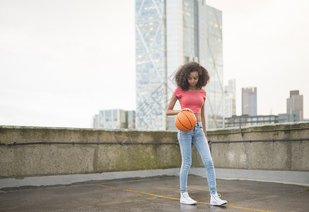 屋顶上打篮球的青年女子图片