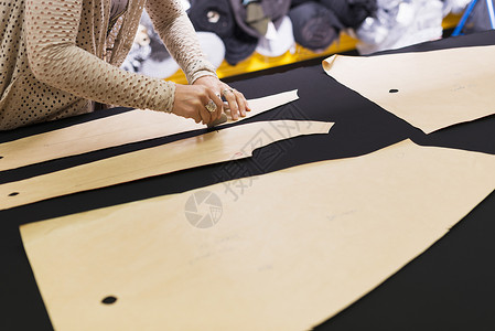成熟裁缝的手在工作台上用粉笔画出形状图片