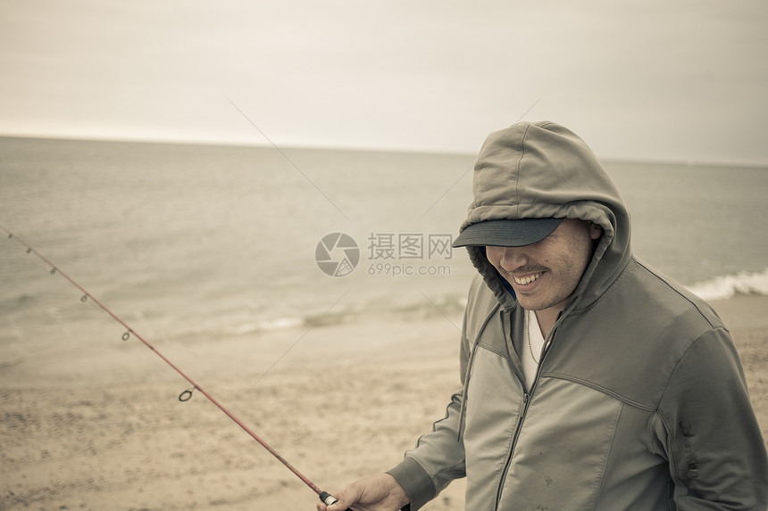 成年男性在海边钓鱼图片