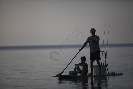 美国密歇根州上大人和十几岁的儿子从滑板上钓鱼图片