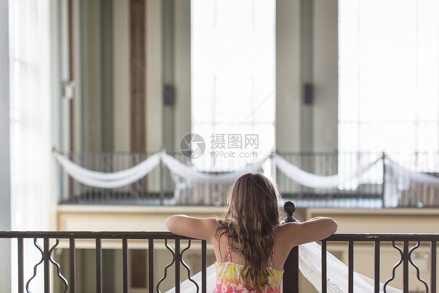 女孩仰视大阳台栏杆的近视图片