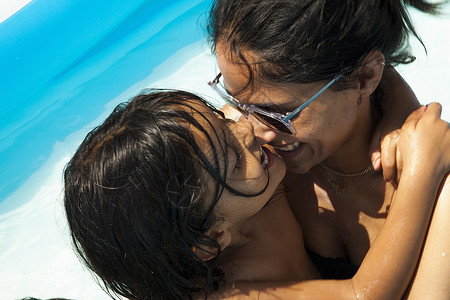 母亲和女儿在游泳池拥抱图片