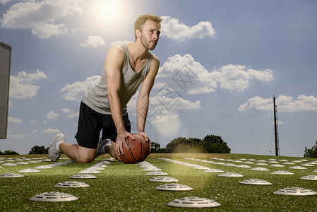 年轻男篮球运动员在体育场做热身运动图片
