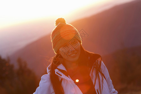 日落时山顶上的年轻女性图片