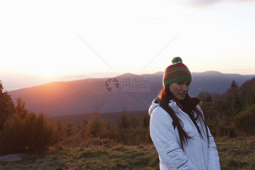 日落时山顶上的年轻女性图片