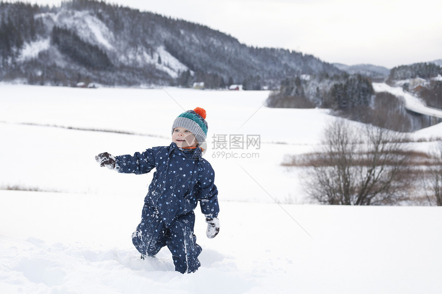 男孩在雪中玩耍图片