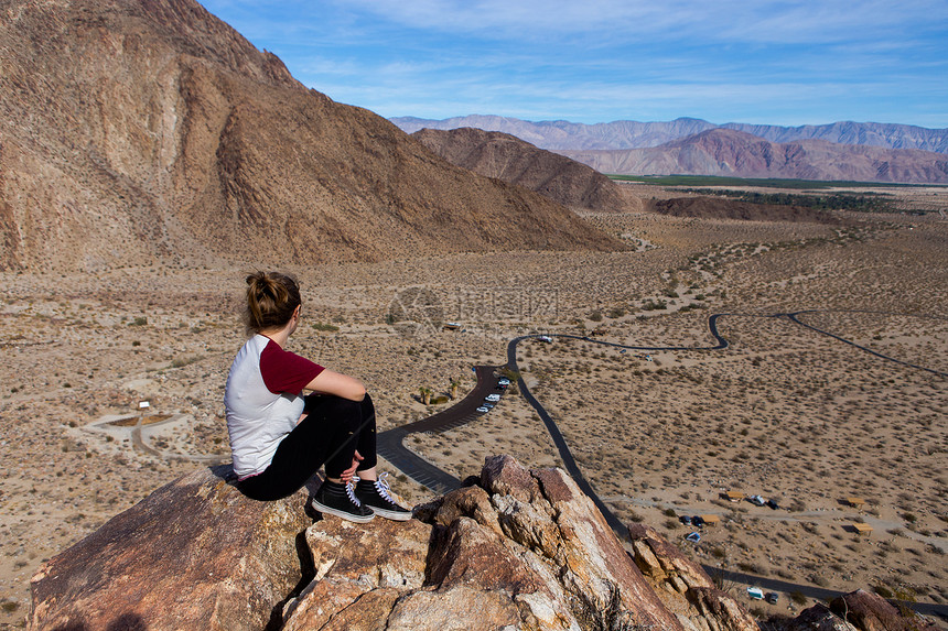 美国加利福尼亚州安扎博雷戈沙漠州立公园一名年轻女子从岩石上眺望风景图片