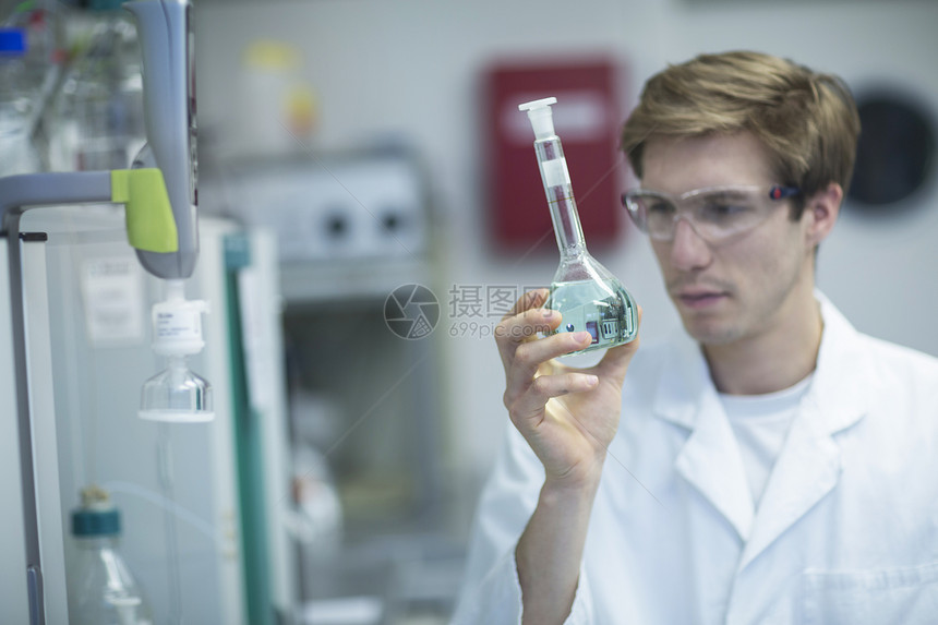研究实验室的男科学家观察容量瓶图片