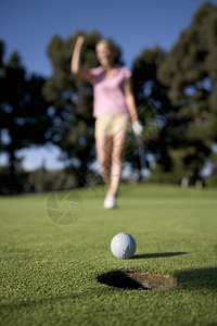 高尔夫球洞边缘的高尔夫球图片