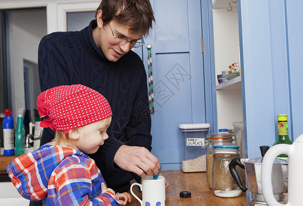 父亲在厨房和儿子一起泡茶图片